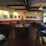Restaurant interior with dining tables, warm lighting, and a decorated Christmas tree.