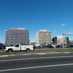 City skyline with modern office buildings under a clear blue sky.