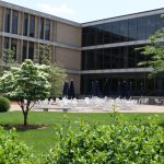 Modern building exterior with outdoor patio seating area on a sunny day.