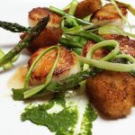Seared scallops with roasted asparagus, crispy fried element, and green sauce.