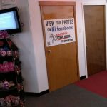 Escape room entrance with promotional signs, video screen, and decorative display.