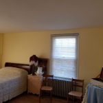 Bedroom with a bed, neutral walls, and a window with blinds.