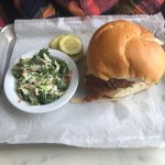 Vegetable hash and a golden bun on white parchment paper.