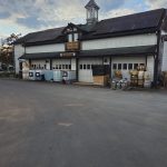 Old stone and wood building with solar panels, featuring "Sourland Mountain" sign.