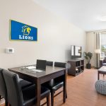 Modern hotel room with desk, blue Lions banner, and seating area.