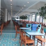 Bright, modern restaurant interior with blue and white tiled floor and dining tables.