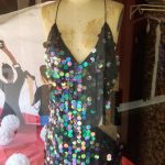 Sequin dress on mannequin in a retail display with red flooring.