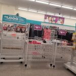 Retail store display with promotional signs and metal shopping carts in the foreground.
