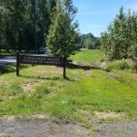 Sign marking Carson Road Woods, Township of Lawrence, next to a dirt path and trees.