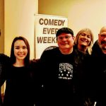 Group of four people posing indoors in front of a "Comedy Every Week" sign.
