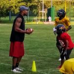 Football practice on a grassy field with players in action.