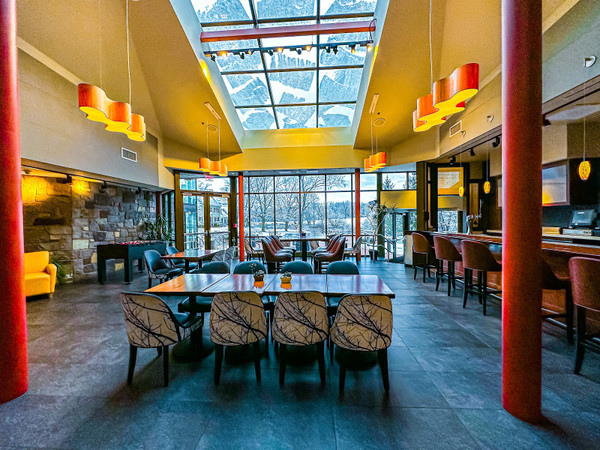 Bright, modern restaurant interior with high skylight and dark tile floor.