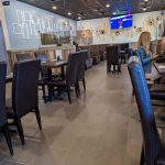 Modern restaurant interior with dining tables, chairs, and contemporary decor.