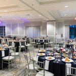 Elegant ballroom set up for a formal event with multiple dining tables and chairs.