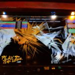 Arcade game screen showing a high-score leaderboard and an explosive, abstract graphic.