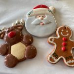 Santa, teddy bear, and gingerbread man ornaments with "2021" on white fabric.