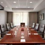 Long conference table in a modern meeting room with chairs and artwork on the walls.