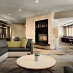 Modern hotel lobby with a fireplace, comfortable seating areas, and contemporary design.