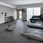 Modern gym interior with treadmills, weights, and exercise equipment in a well-lit space.