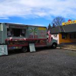 Food truck advertising "Latin Bites" parked near a Cream King building under a blue sky.