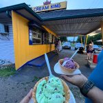 Ice cream cones at Cream King shop with people in the background.