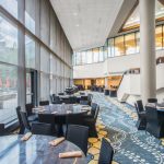 Modern hotel dining area with large windows overlooking greenery and blue patterned floor.