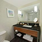 Modern bathroom vanity with mirror, sink, and dark tile floor.