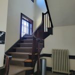 Interior view of a modern staircase with high ceilings and natural light.