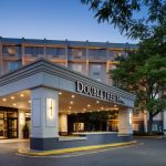 DoubleTree by Hilton hotel entrance at twilight with modern architecture and surrounding trees.