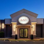 Modern restaurant entrance with "BLAZE" sign at twilight.