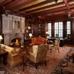 Ornate, richly decorated library with a fireplace, antique furniture, and detailed wood paneling.