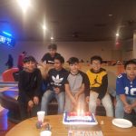 Group of young boys posing indoors with arcade games visible in the background.