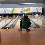 Person bowling on a lane in an indoor bowling alley.