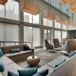 Modern, bright hotel lobby with comfortable seating areas and large windows.