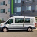 White cargo van parked in front of a modern, multi-story building with "element" branding.