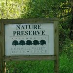 Nature Preserve sign for Hopewell Valley Open Space, set outdoors among trees and grass.