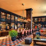 Luxurious library interior with dark wood shelves, leather seating, and a patterned tile floor.