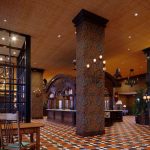 Grand, ornate hotel lobby with high ceilings, patterned floor, and large architectural columns.