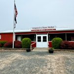 Red barn storefront for Griggistown Farm Market with American flag flying.