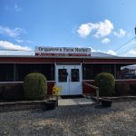 Griggstown Farm Market storefront with sign, featuring a rustic building and landscaping.