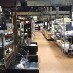 Interior view of a large market hall with food displays and high wooden beams.