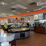Buffet line with food display, serving counter, and restaurant interior.
