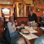 Group gathered around a wooden table in a rustic restaurant setting.