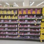 Shelves stocked with various bags of Starbucks coffee and snacks in a retail store aisle.