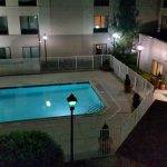 Night view of a modern apartment complex with an illuminated outdoor swimming pool.