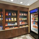 Shelves stocked with snacks and a commercial refrigerator displaying drinks.