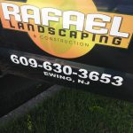 Rafael Landscaping & Construction company logo and phone number on a dark vehicle.