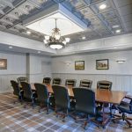 Conference room with large table, chairs, and ornate coffered ceiling.