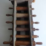 Wooden rolling pin rack with multiple dowels, vintage kitchen utensil storage.