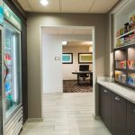 Refrigerated display case next to a counter area in a modern convenience store interior.